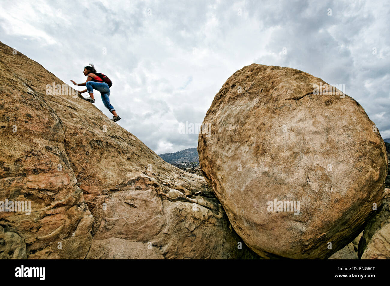 Hispanic woman climbing rocky hillside Stock Photo
