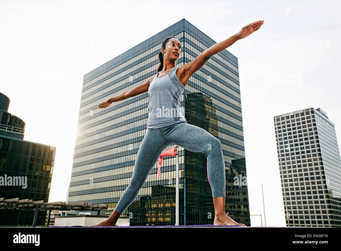 African American woman practicing yoga on urban rooftop Stock Photo