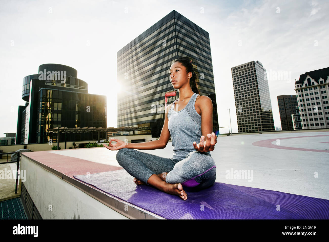 African American woman meditating on urban rooftop Stock Photo