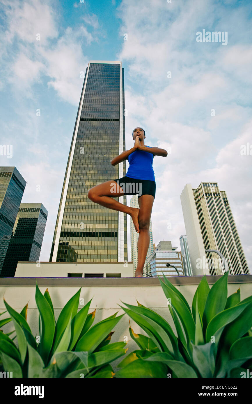 African American woman practicing yoga on urban rooftop Stock Photo