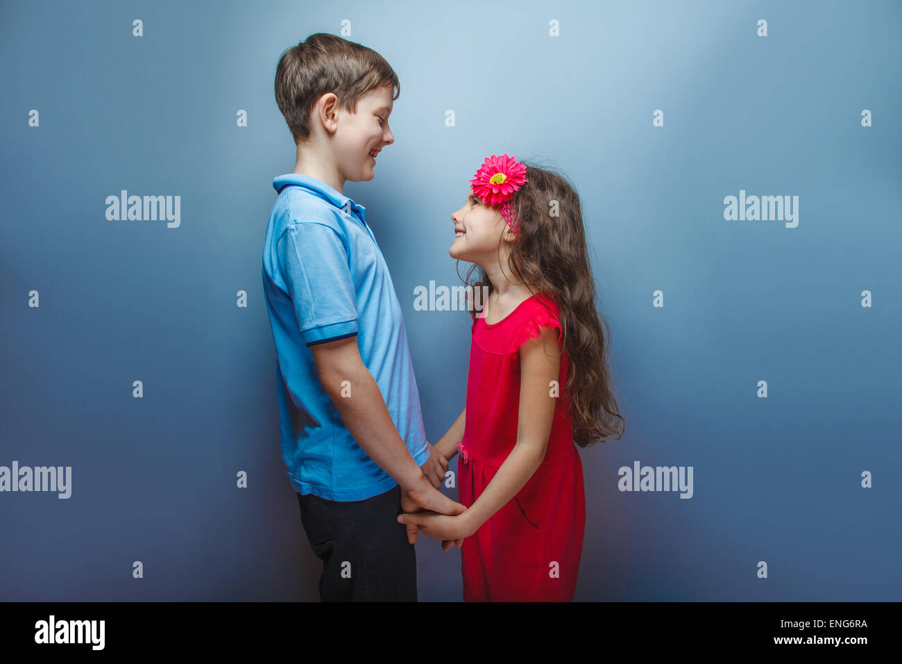 teen girl holding hands teenage boy on a gray background Stock Photo ...