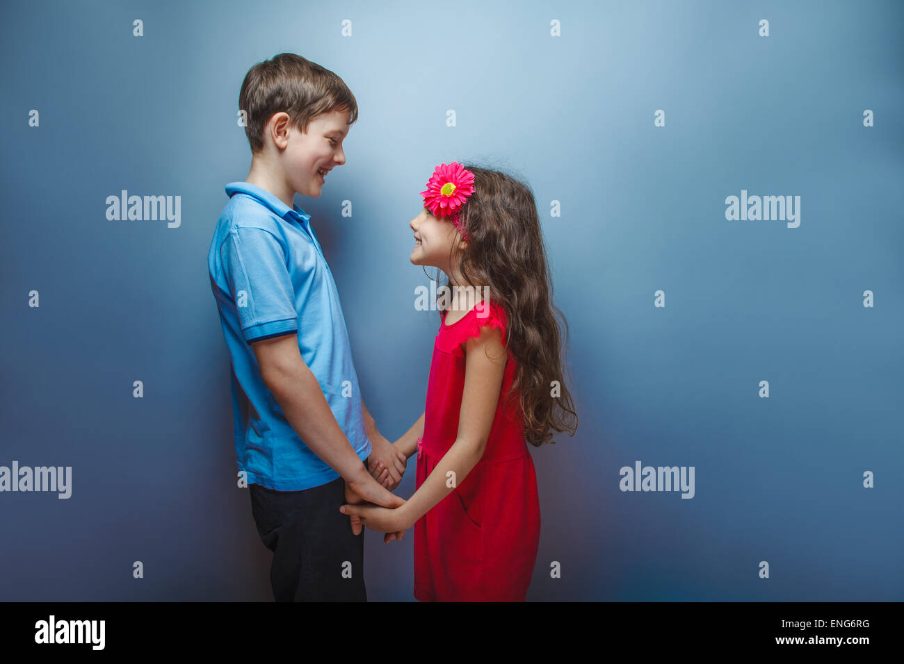 teen girl holding hands teenage boy on a gray background Stock Photo ...