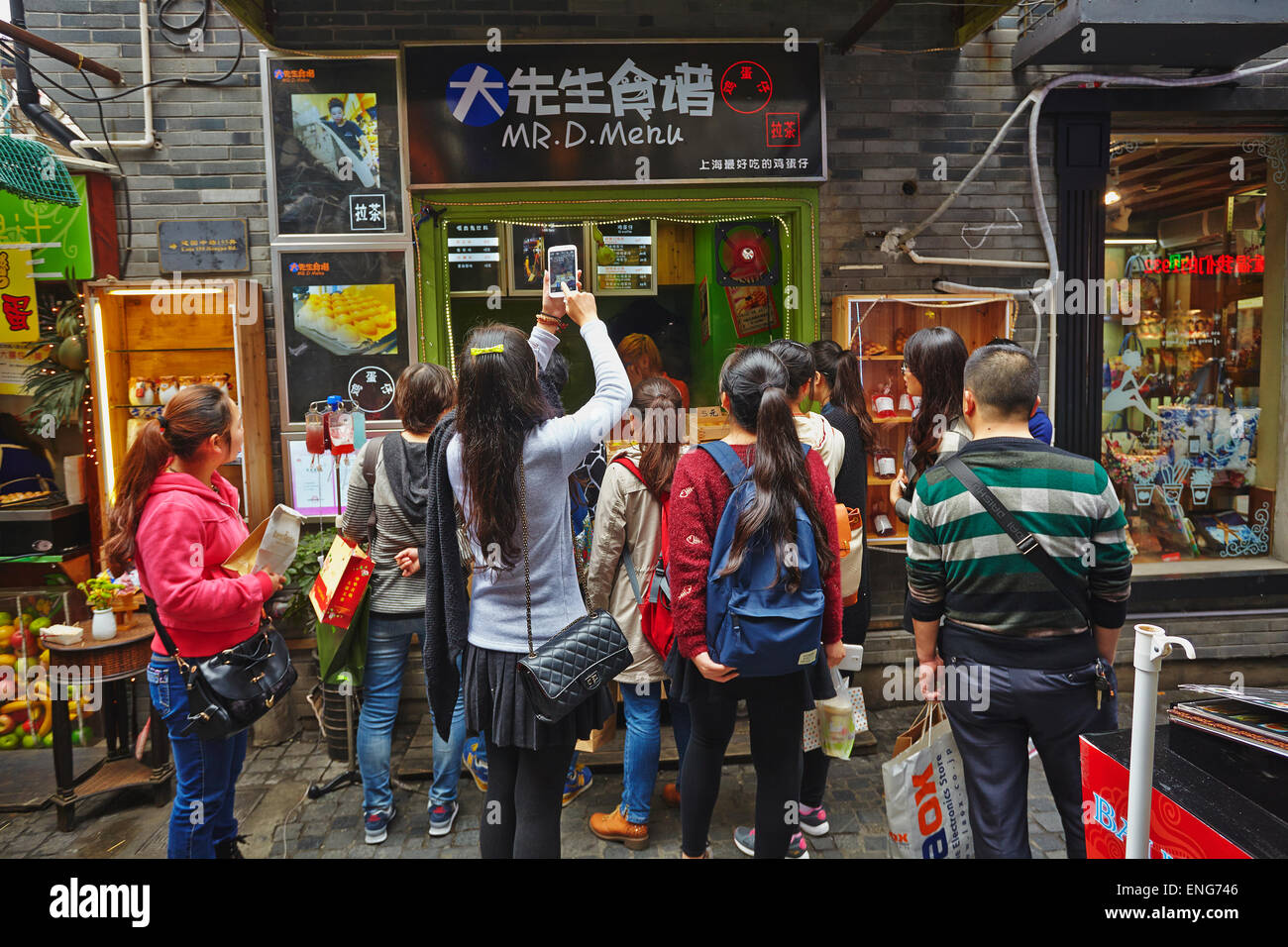 A crowd outside a cafe in a lane in Tianzifang, the old French Concession Area, now a  tourist attraction, in  Shanghai, China. Stock Photo