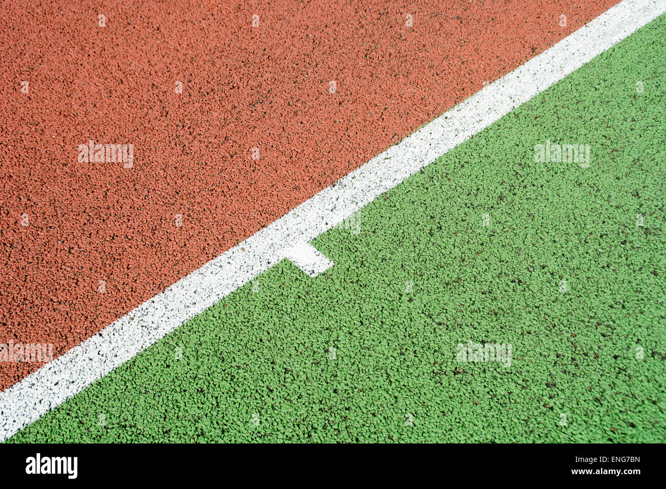 Closeup on a tennis court baseline on a red and green surface Stock Photo
