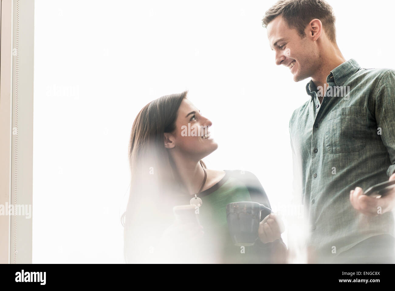 A man and woman talking in an office over coffee. Stock Photo