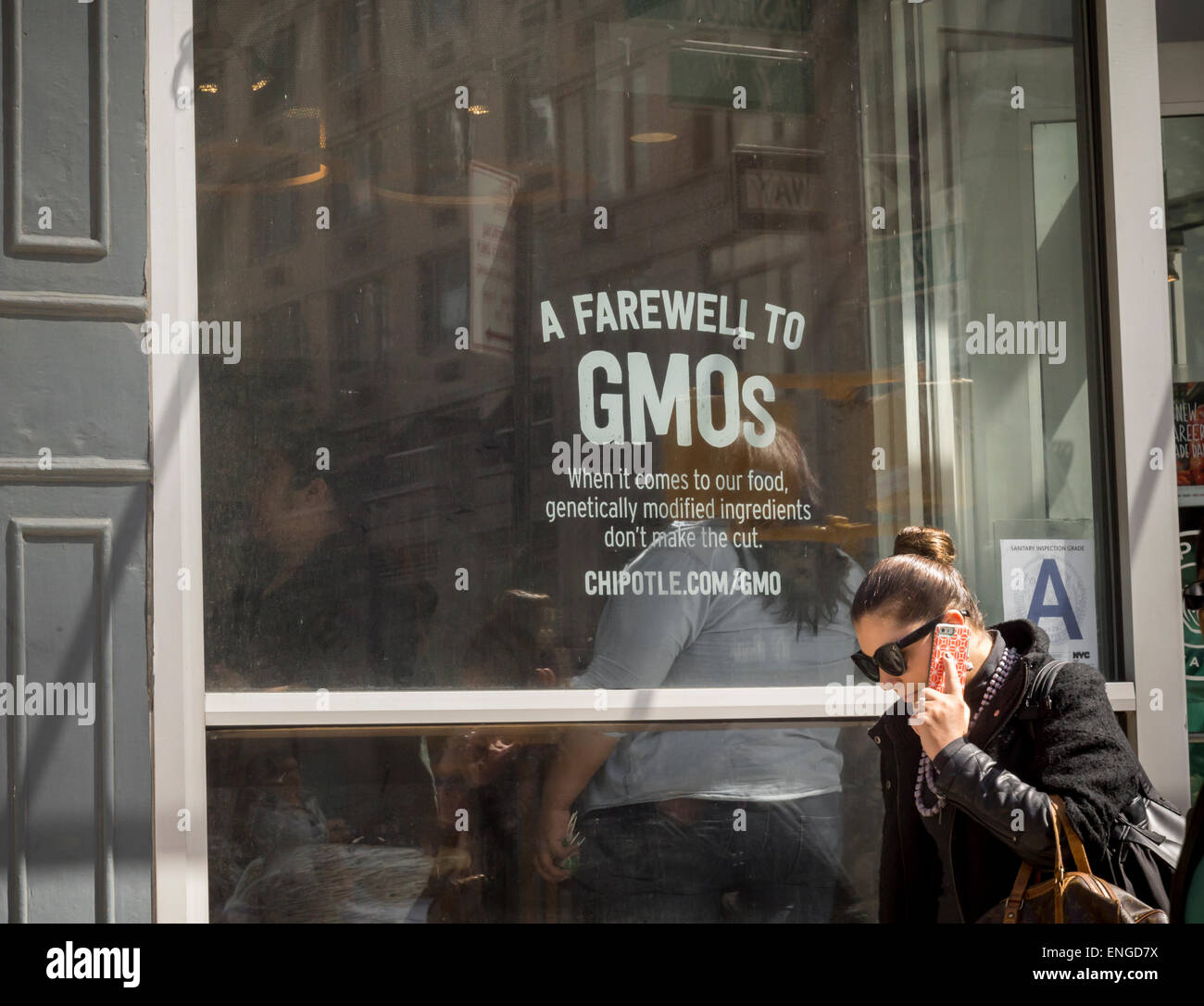 A sign in the window of a Chipotle Mexican Grill restaurant in Chelsea in New York espouses their commitment to using non-GMO ingredients, seen on Thursday, April 30, 2015. Chipotle has completed its phase out of the use of genetically modified organism ingredients. (© Richard B. Levine) Stock Photo