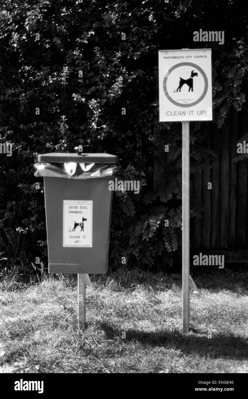 sign warning to clean up after your dog and bin to put its waste in Stock Photo