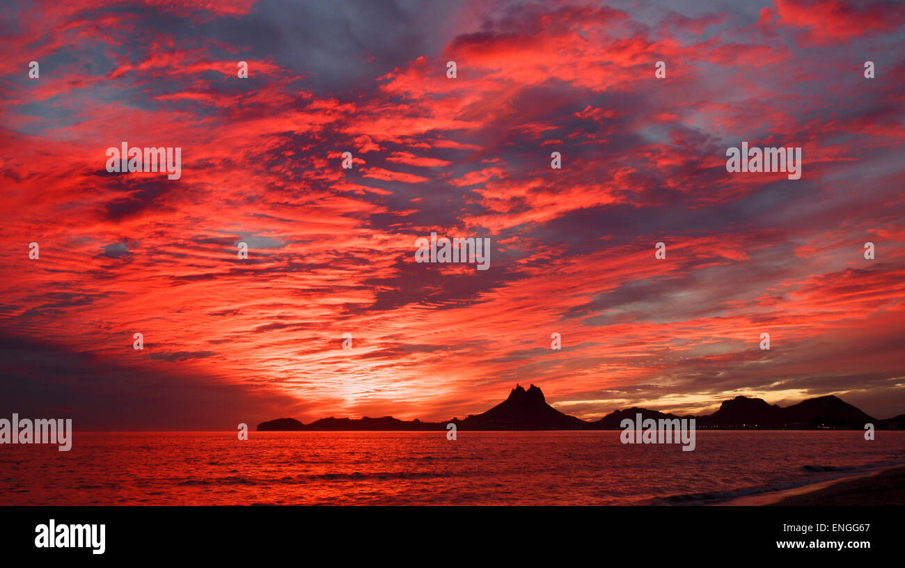 Clouds glow with colour as the sun sets over Mount Tetakawi, Mexico Stock Photo