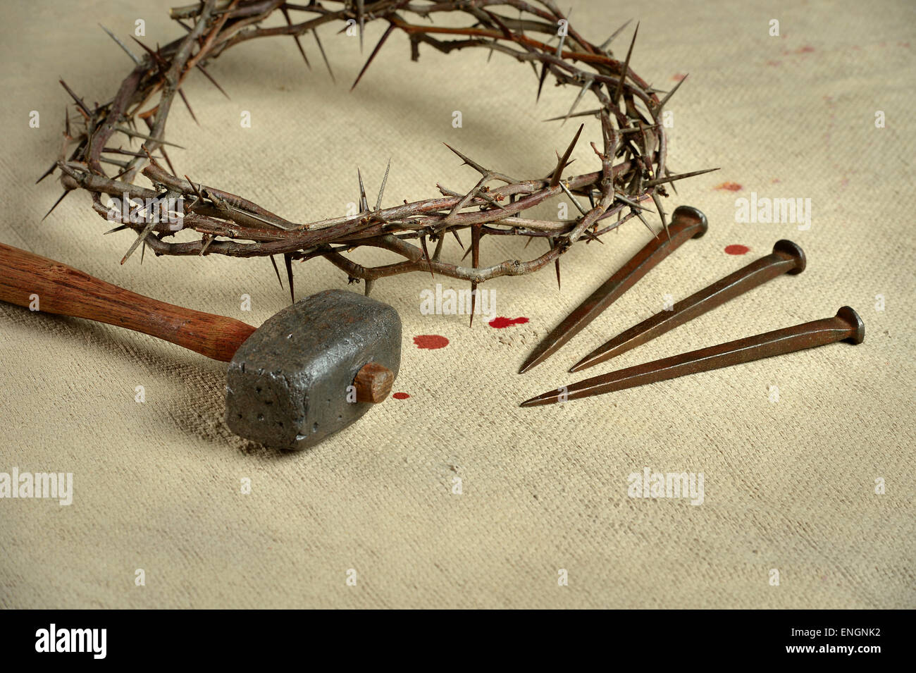 Christian symbols of the crucifixion with crown of thorns, nails and mallet on distressed cloth Stock Photo