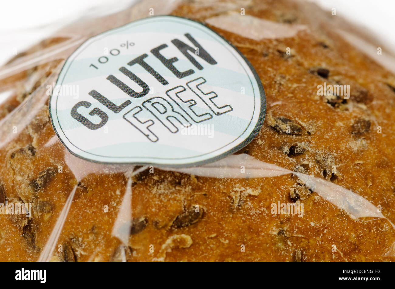 '100% Gluten Free' sticker on a loaf of brown seeded bread. Stock Photo