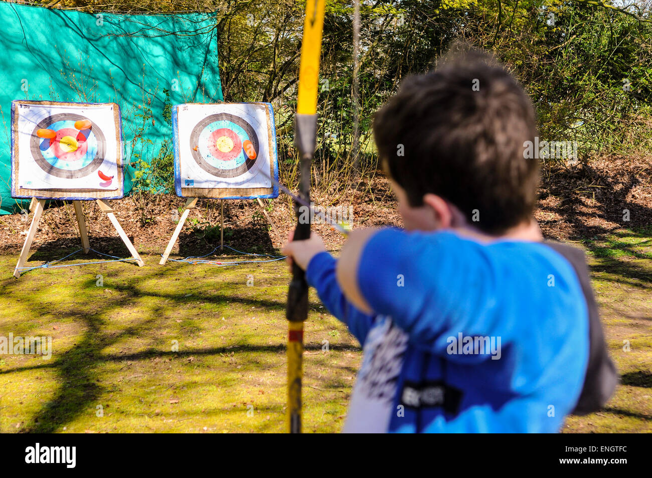 A young boy uses a bow and arrow during an archery session Stock Photo