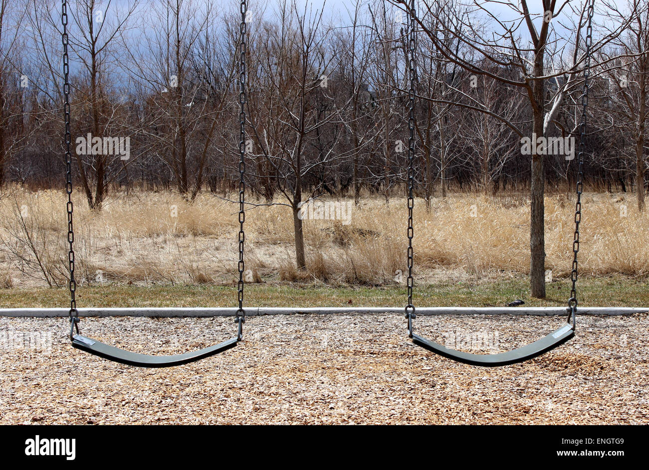 Image of two lonely swing in a Canadian playground Stock Photo