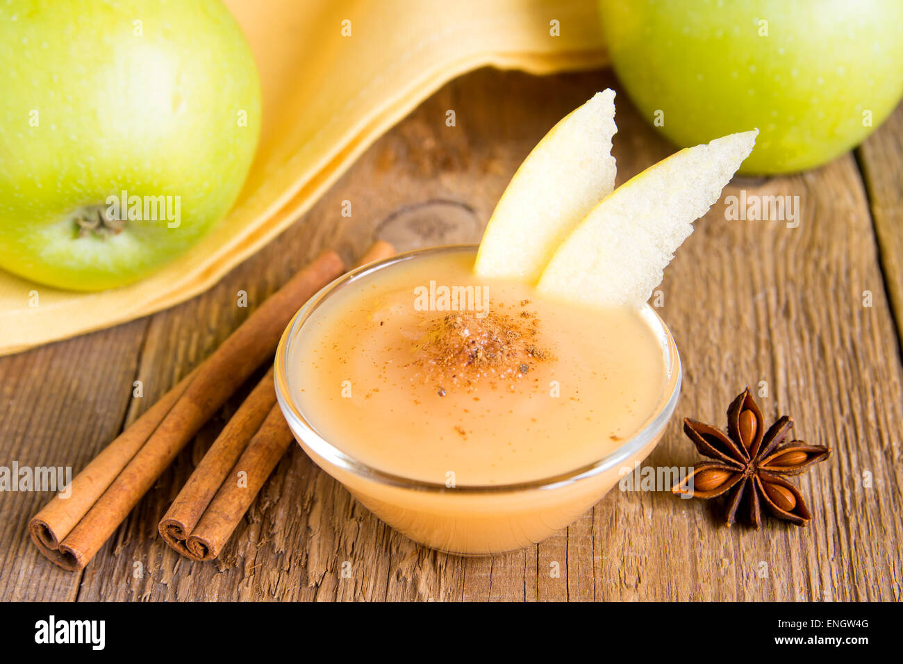 Fresh homemade applesauce (apple puree, baby food) with cinnamon (spices), spoon and apples on