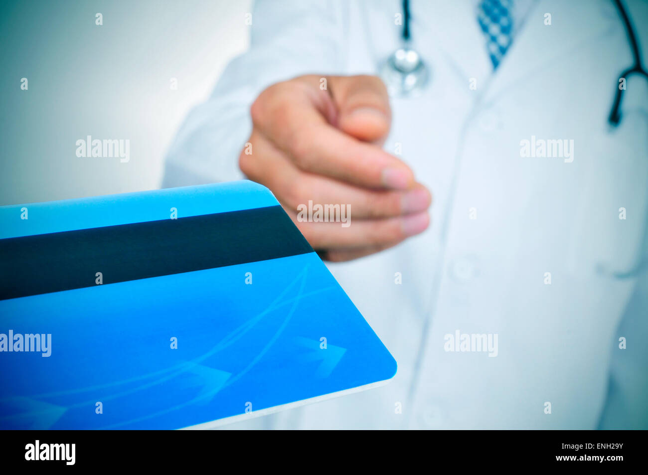 closeup of a young caucasian doctor accepting a blue credit card Stock Photo
