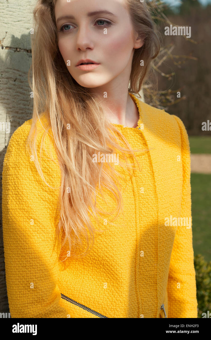 Portrait Of Young Woman In Yellow Jacket With Blonde Hair Stock