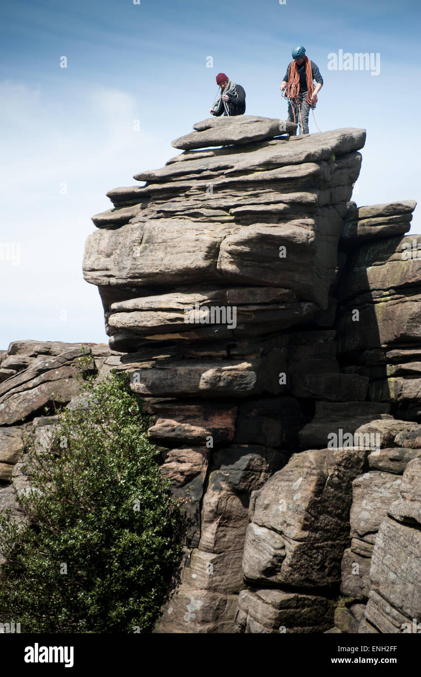 Two climbers at the top of Stanage Edge in the Peak District Stock