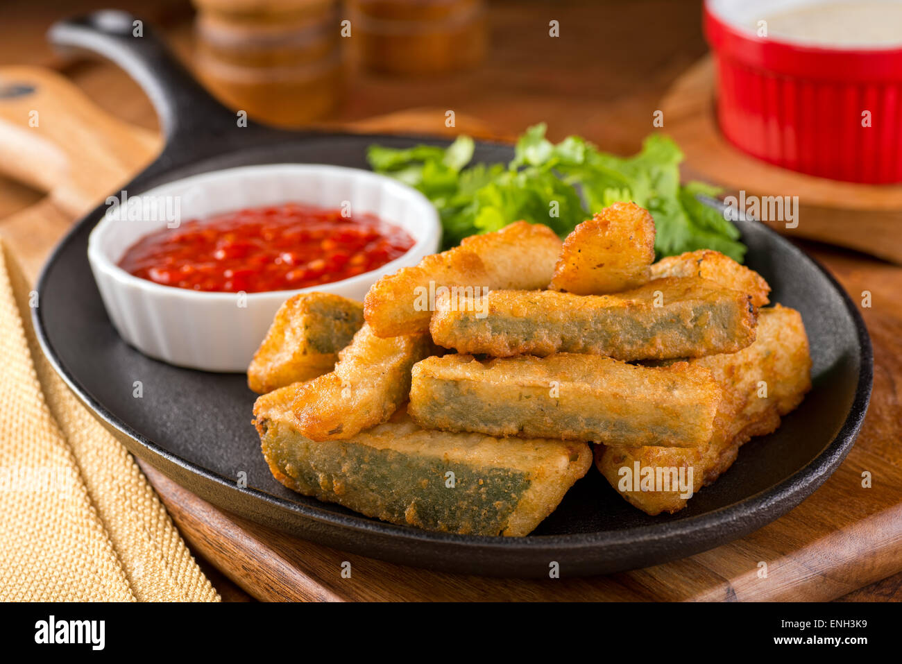 Delicious deep fried zucchini sticks with marinara dipping sauce. Stock Photo