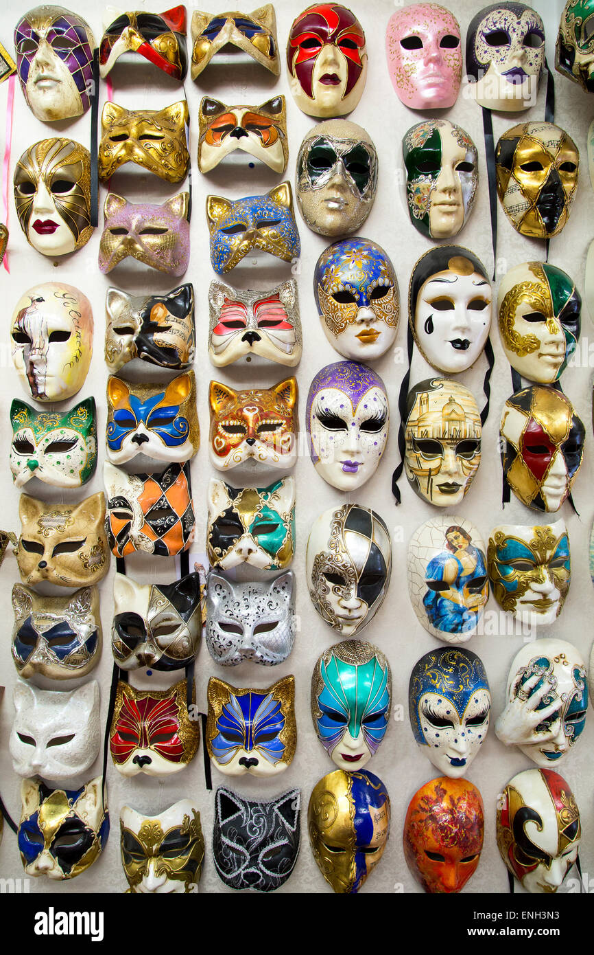 Full of beautiful elegant traditional venetian masks are hanged on wall for street carnival in Venice, Italy Stock Photo
