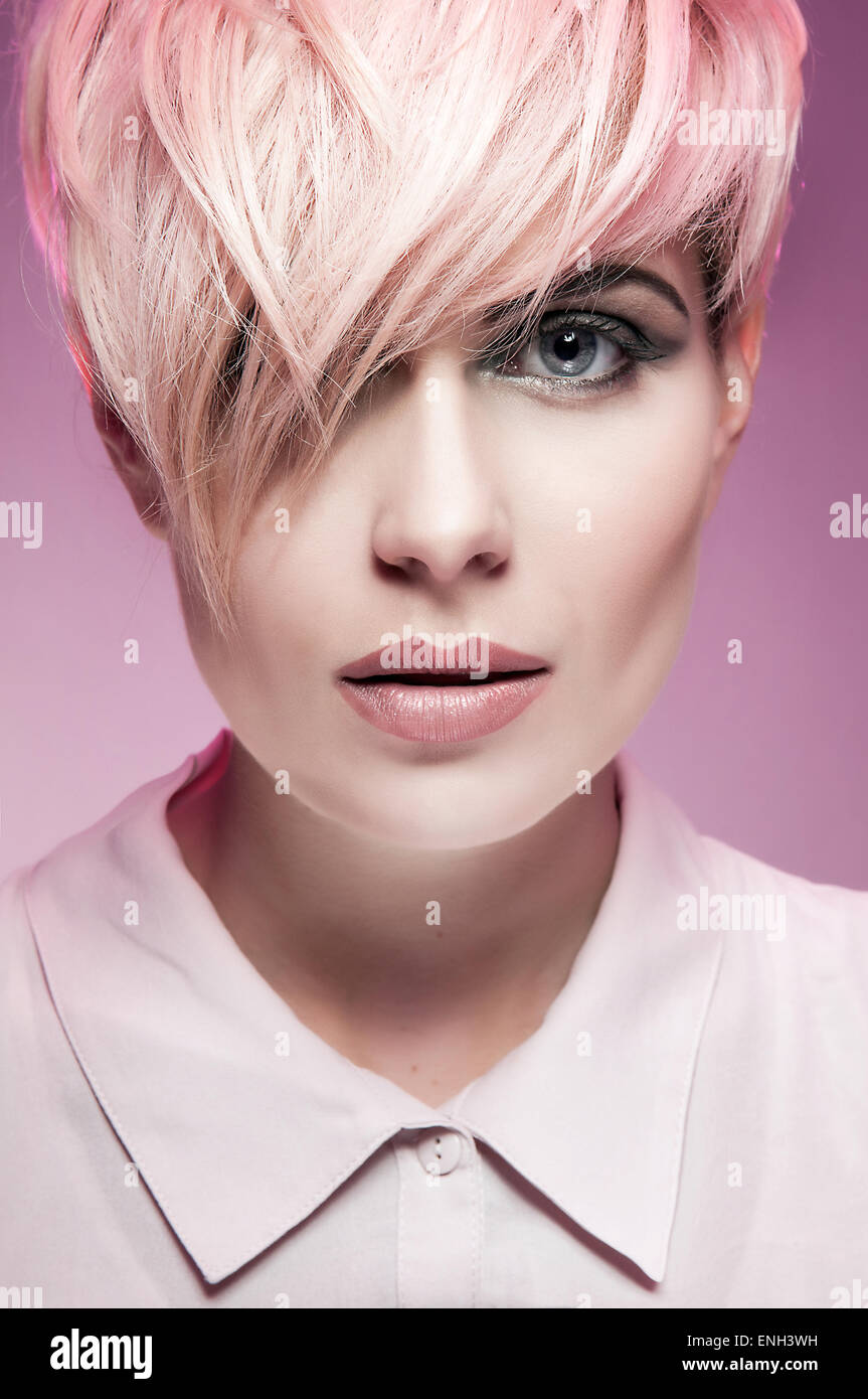Portrait of young woman with messy cropped pink hair Stock Photo