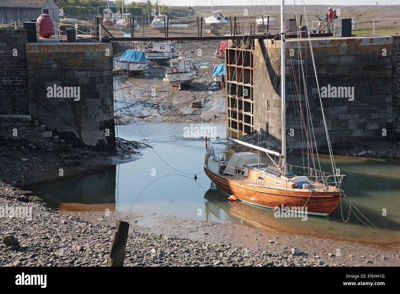 Varnished wooden yacht in Porlock Weir Harbour at low tide Stock Photo