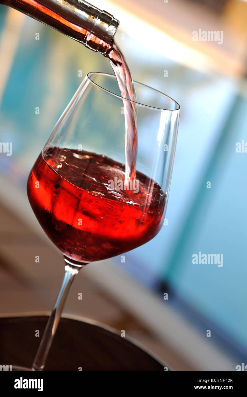 Rosé Pouring a glass of light rose wine in sunny summer pool terrace