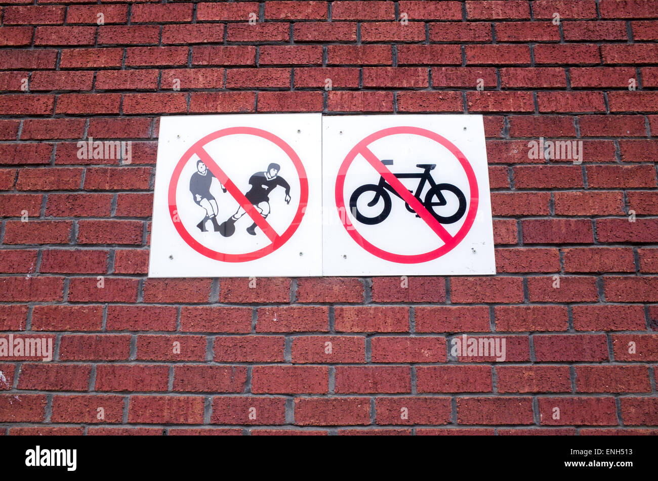No cycling or ball games signs on a brick wall at a council housing estate, UK Stock Photo