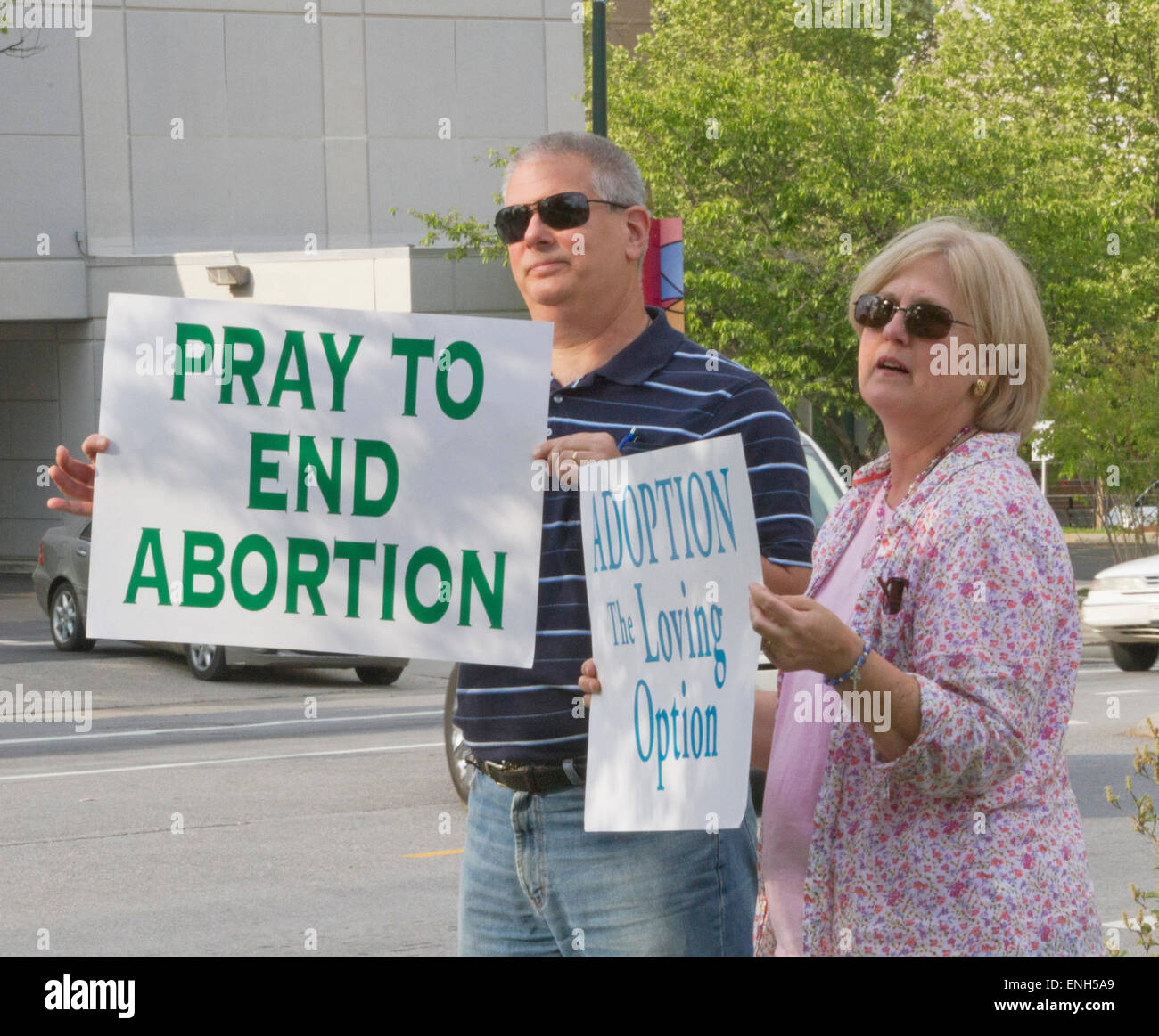 Asheville, North Carolina, USA - May 4, 2015:  An older man and woman hold anti-abortion and pro adoption signs at a rally protesting North Carolina abortion Bill #465, which requires a much longer waiting period for women seeking abortions on May 4, 2015 in downtown Asheville, NC Credit:  Judith Bicking/Alamy Live News Stock Photo