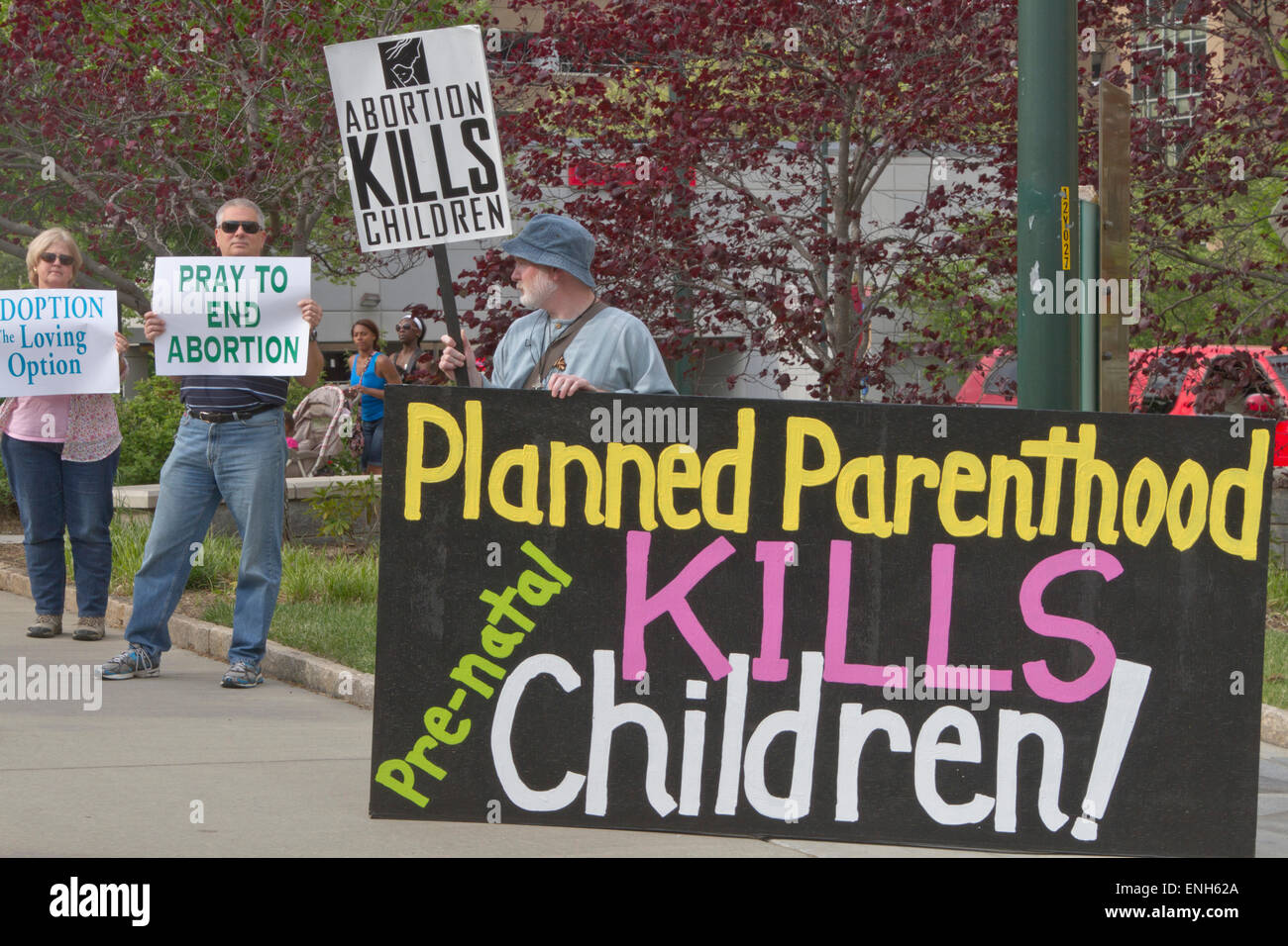 Asheville, North Carolina, USA - May 4, 2015:  Two men and one woman hold anti-abortion signs at a rally protesting North Carolina abortion bill #465 which requires a much longer waiting period for women seeking abortions on May 4, 2015 in downtown Asheville, NC Credit:  Judith Bicking/Alamy Live News Stock Photo