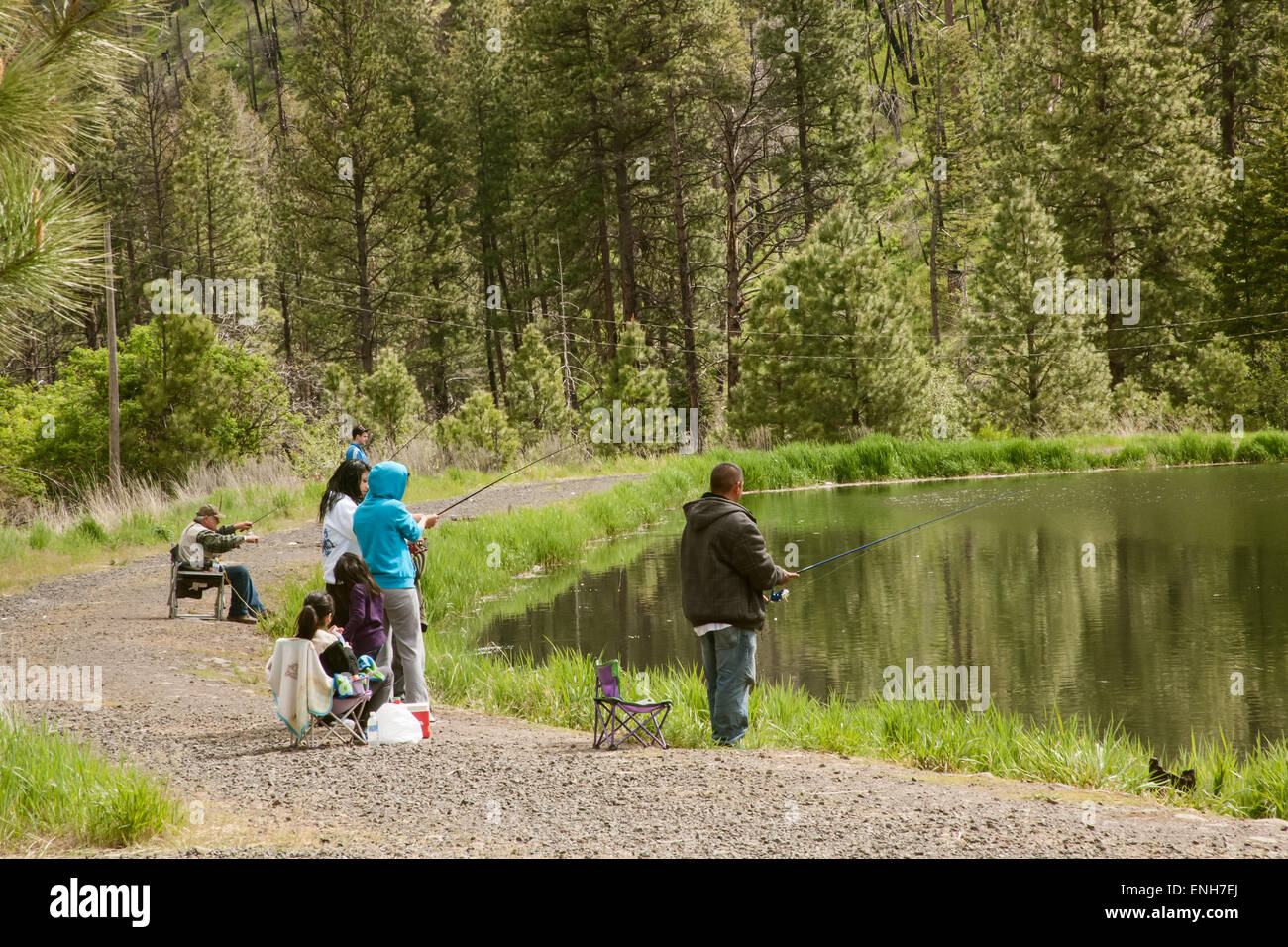Latino and Caucasian families fishing in Donnie Lake in Camp Wooten State Park, Washington, USA Stock Photo