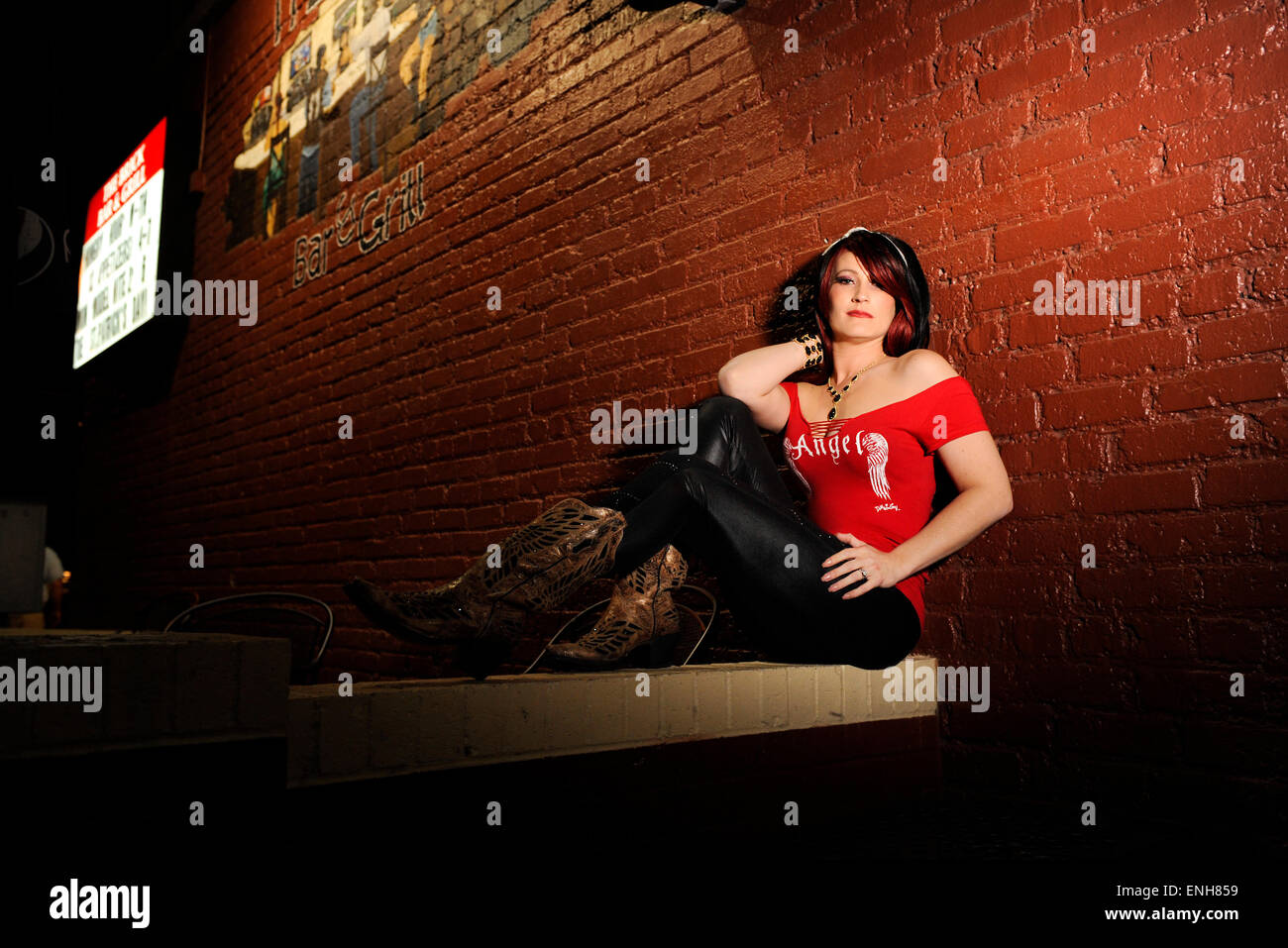 Model standing outside of a bar with Marquee and business sign Stock Photo
