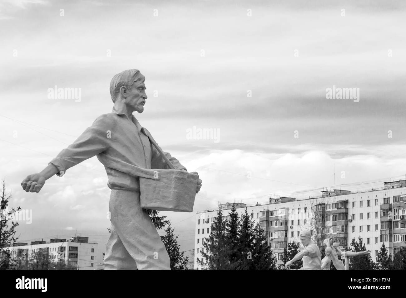 Stone man walking forward casting seeds towards the sky in monochrome Stock Photo