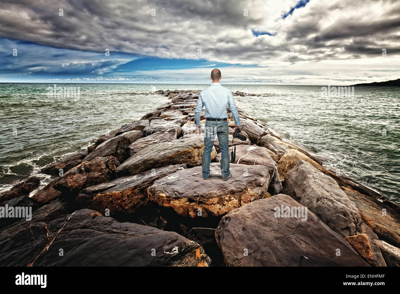 standing photographer on sea rock reef Stock Photo