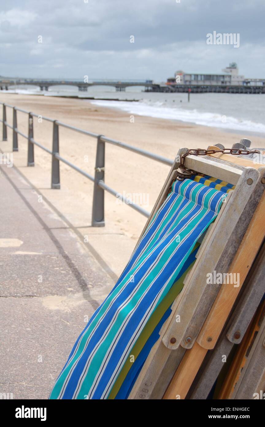 A stack of deck chairs resting up against some railings. Bournemouth
