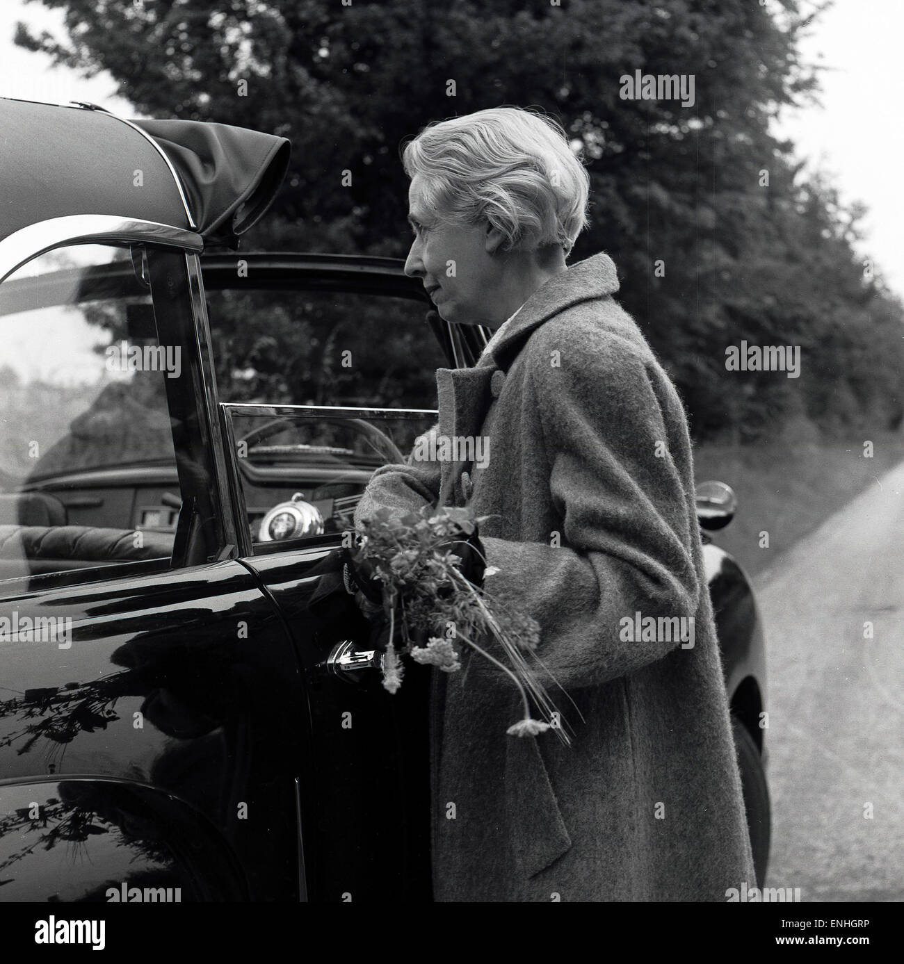 historical, 1950s, elderly lady getting into an open top car. Stock Photo