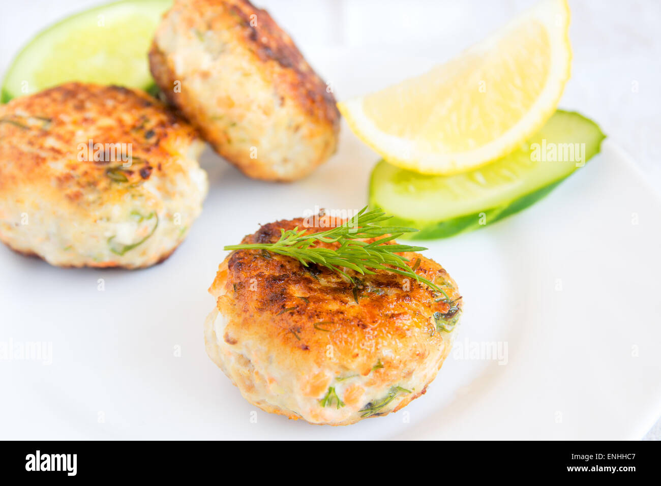 Homemade fish cakes with dill and lemon on white plate Stock Photo