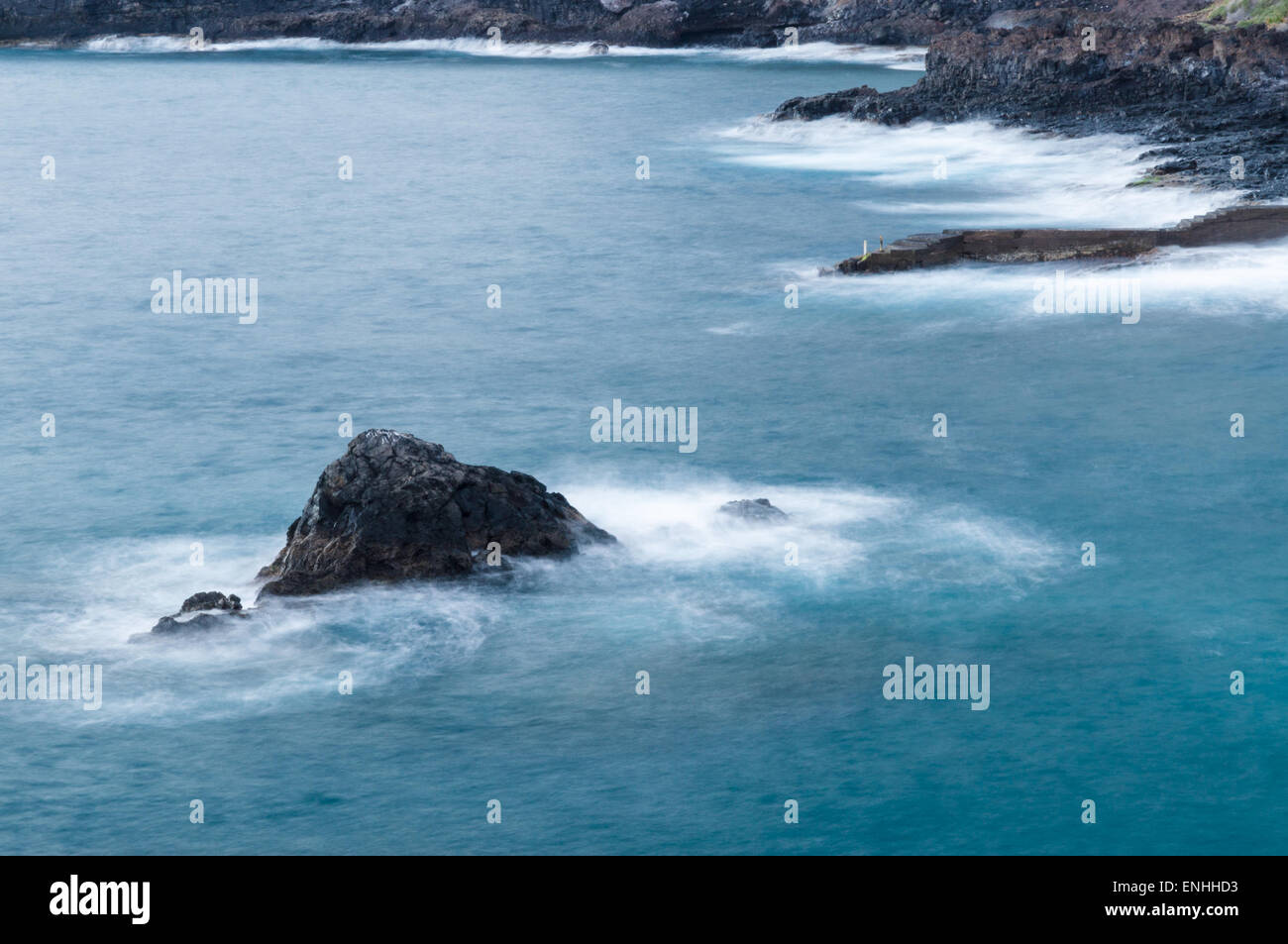 Long exposure view of rocky coastline with deep blue sea water. Los Gigantes, Tenerife, Canary islands Stock Photo