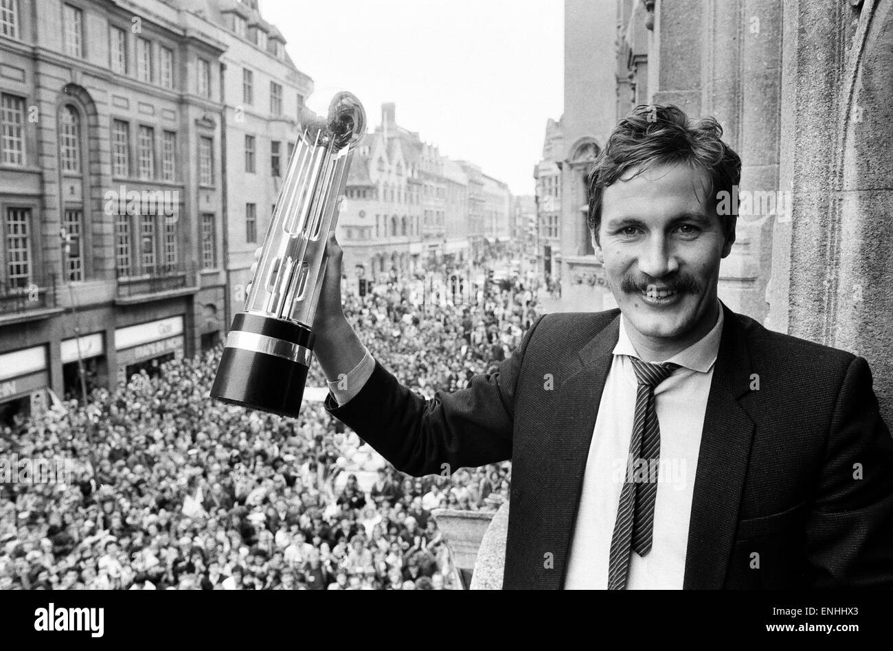 Oxford United footballer holds aloft the Second Division Championship trophy on an open top bus parade, cheered by thousands of fans who lined the streets of Oxford to celebrate their team's success. 13th May 1985. Stock Photo