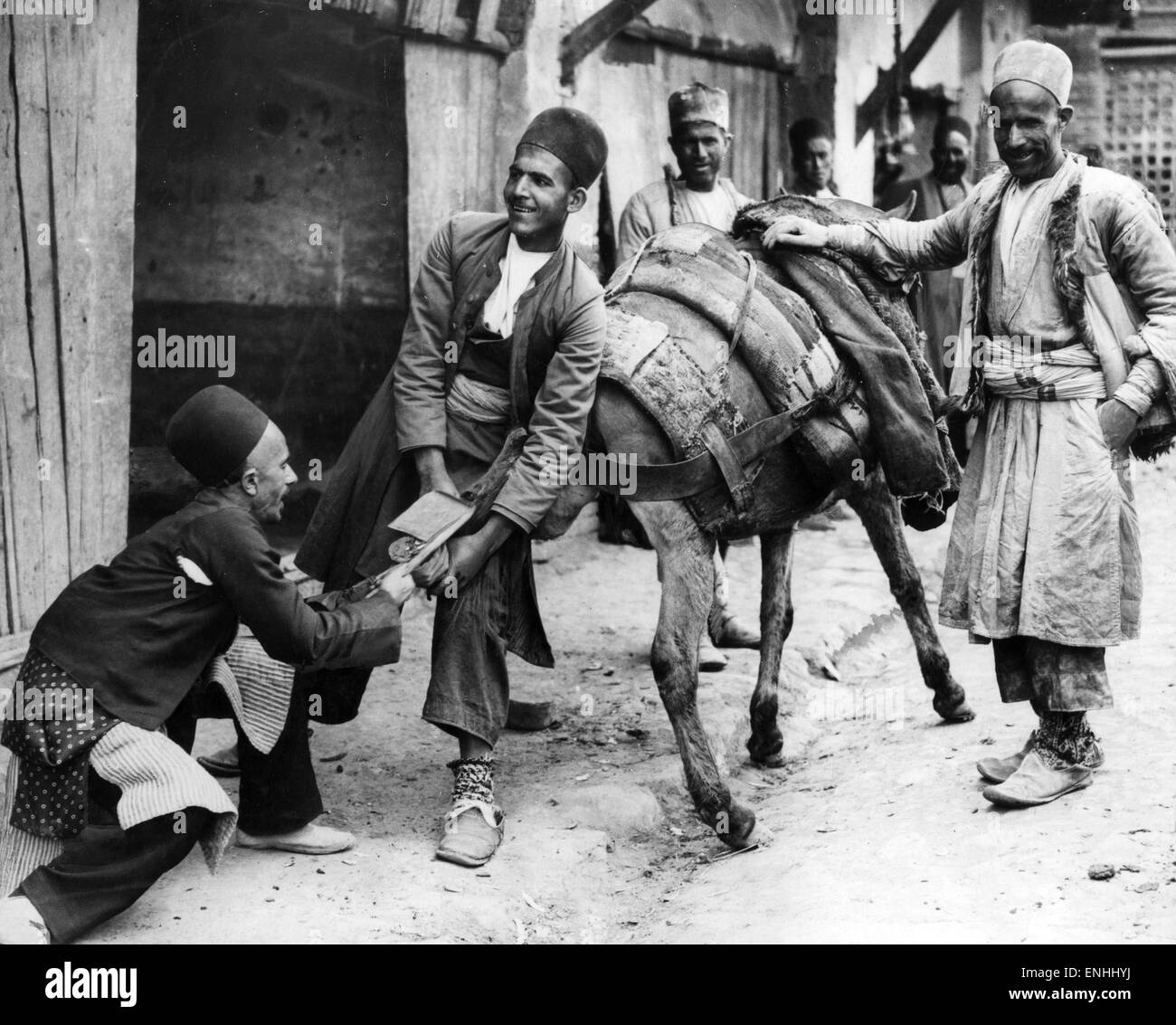 Persians shoeing a mule in Hamadan, capital city of Hamadan Province of Iran. Circa 1926. Hamadan is believed to be among the oldest Iranian cities and one of the oldest in the world. Stock Photo