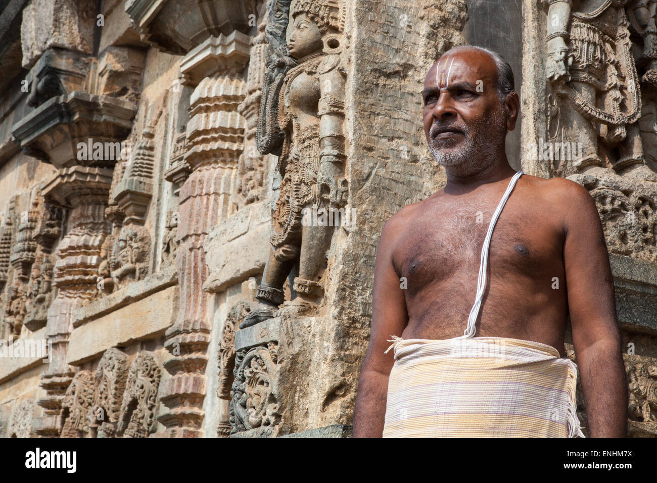A Brahmin priest stands in front of the Chennakesava Temple in Belur Stock Photo