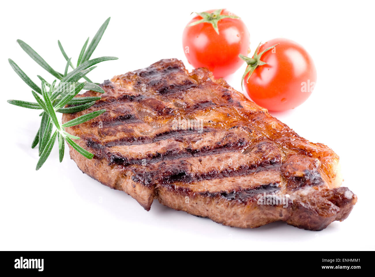 Strip steak on white plate. Rosemary and tomatoes garnish. Stock Photo