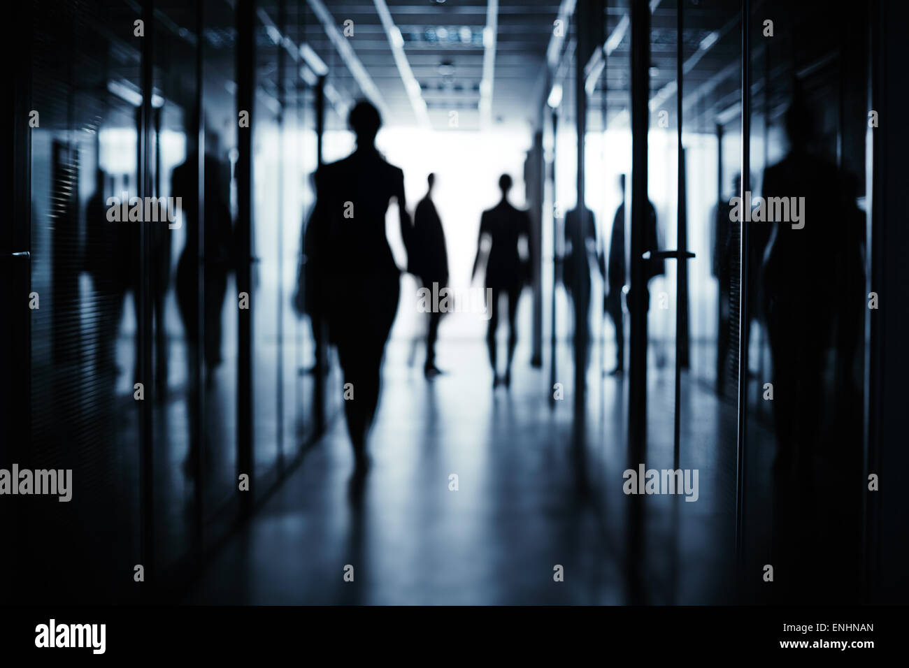Silhouettes of several business people in corridor of office building ...