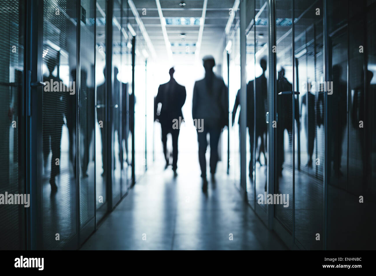 Several business people walking inside office building Stock Photo