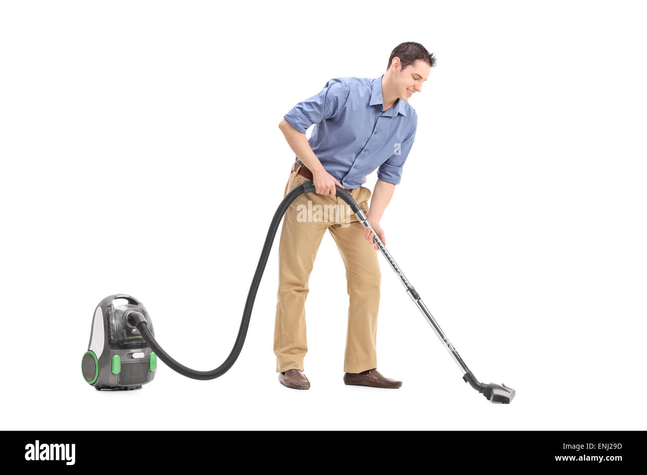 Studio shot of a cheerful young man using a vacuum cleaner isolated on ...