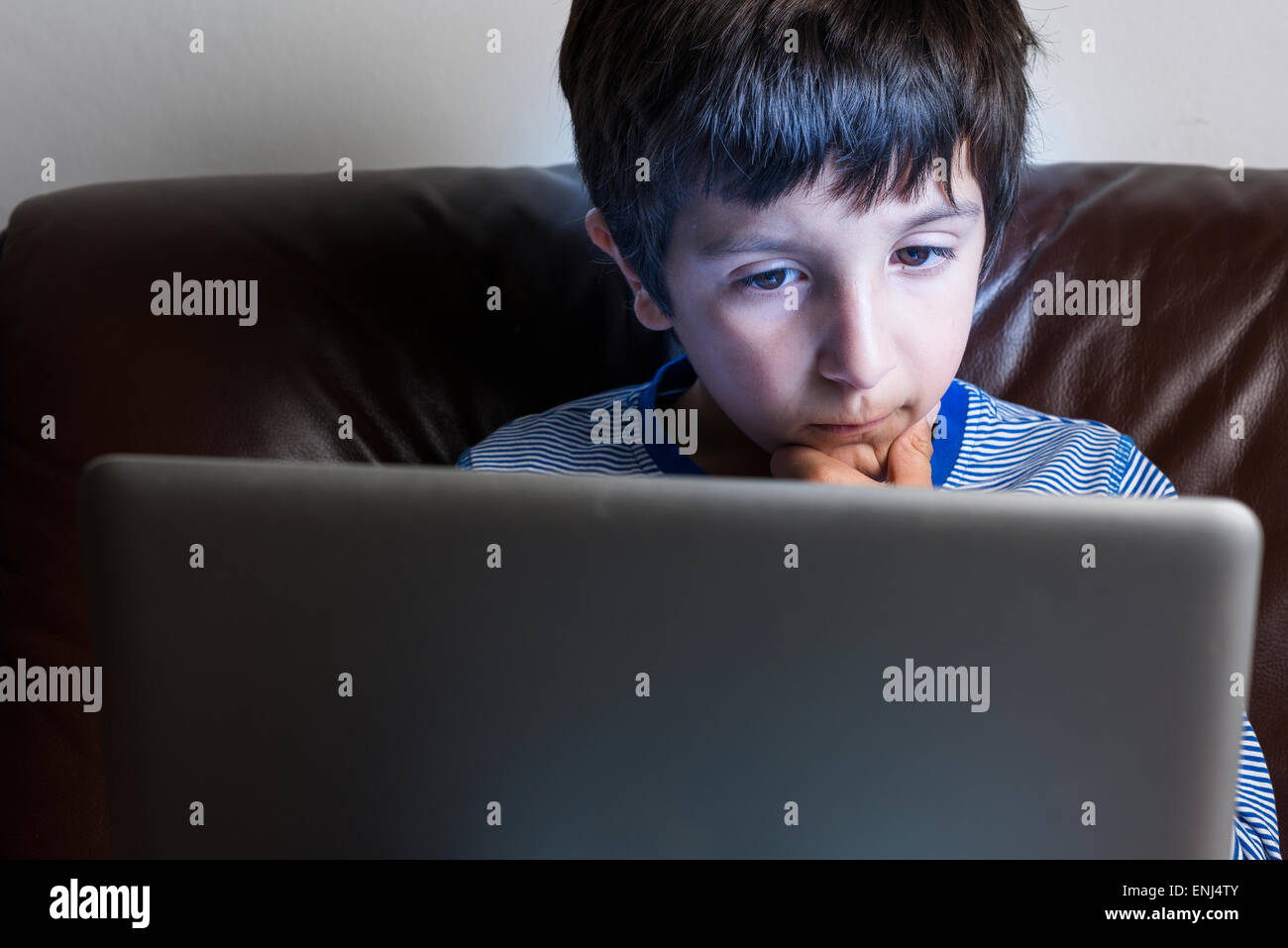 Boy ,6-7,on  laptop computer at night Stock Photo