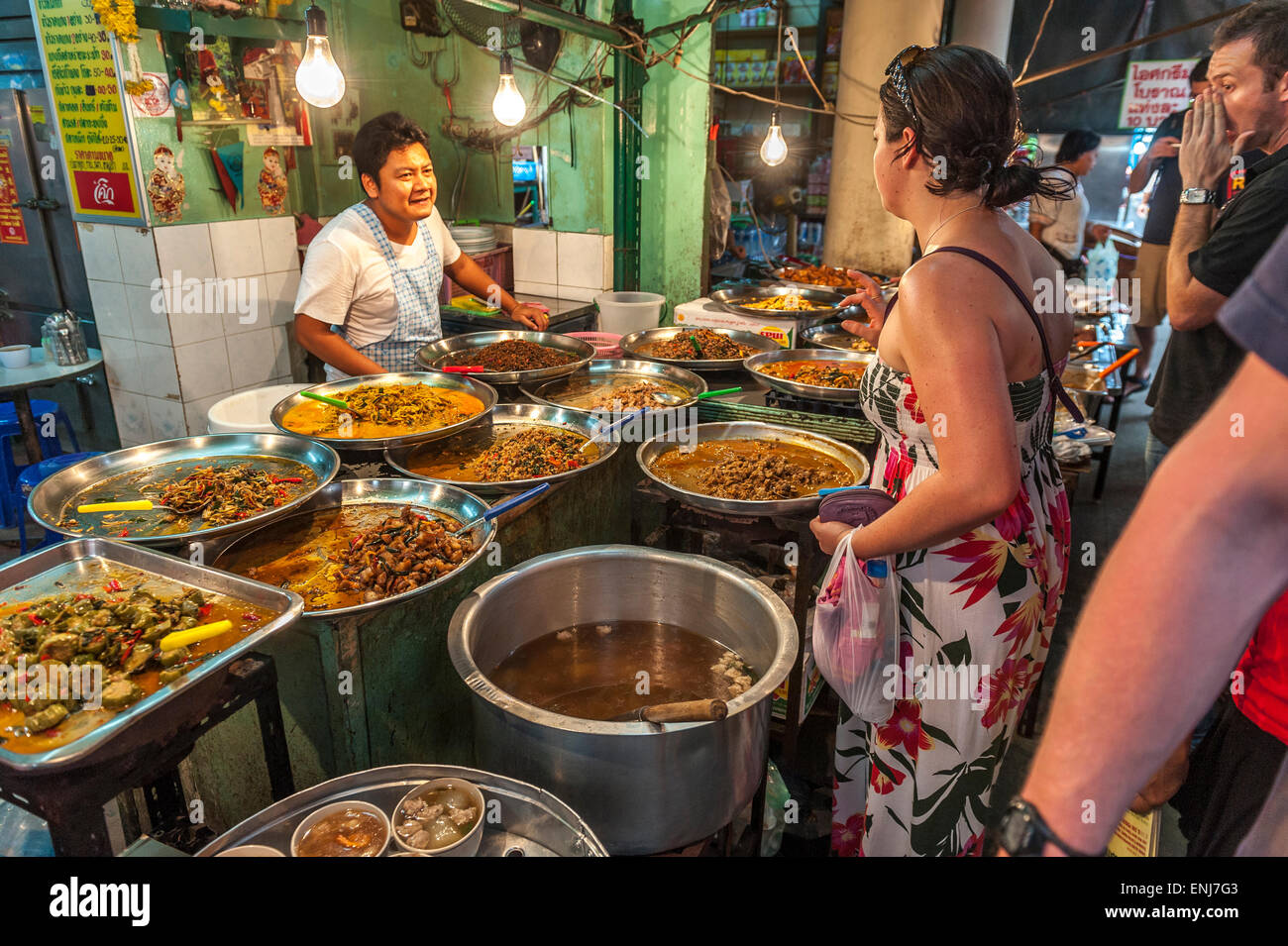 A female tourist ordering a selection of Thai food from a stall at the Tha Chang boat pier market. Bangkok. Thailand Stock Photo