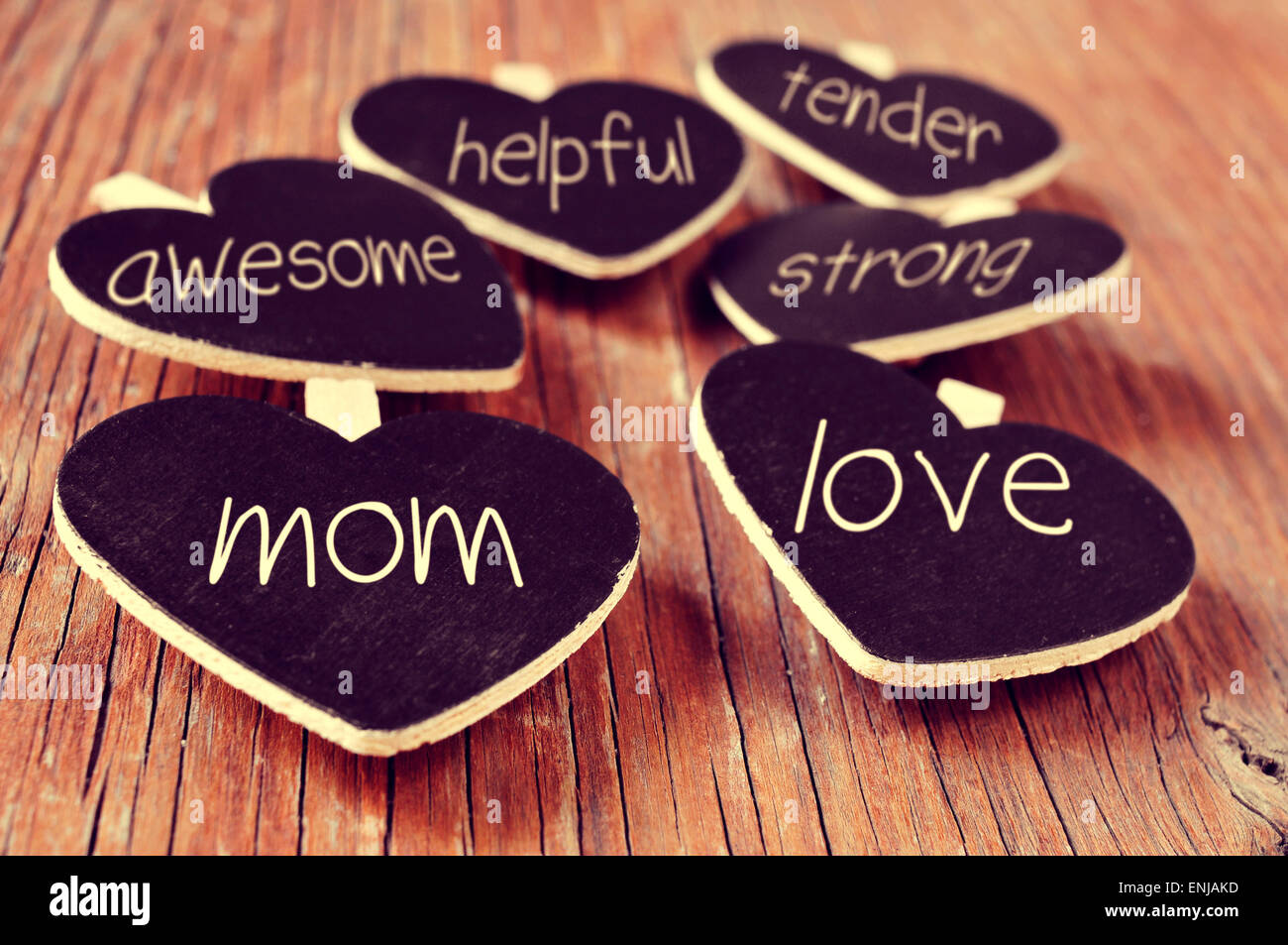 some heart-shaped blackboards with concepts referring to a good mom written in them, such as love, helpful, awesome, tender or s Stock Photo