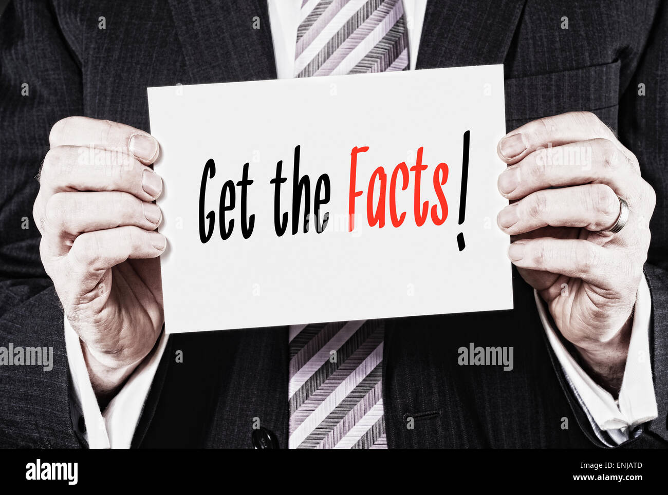 A businessman holding a card with the words, Get The Facts, written on it. Stock Photo