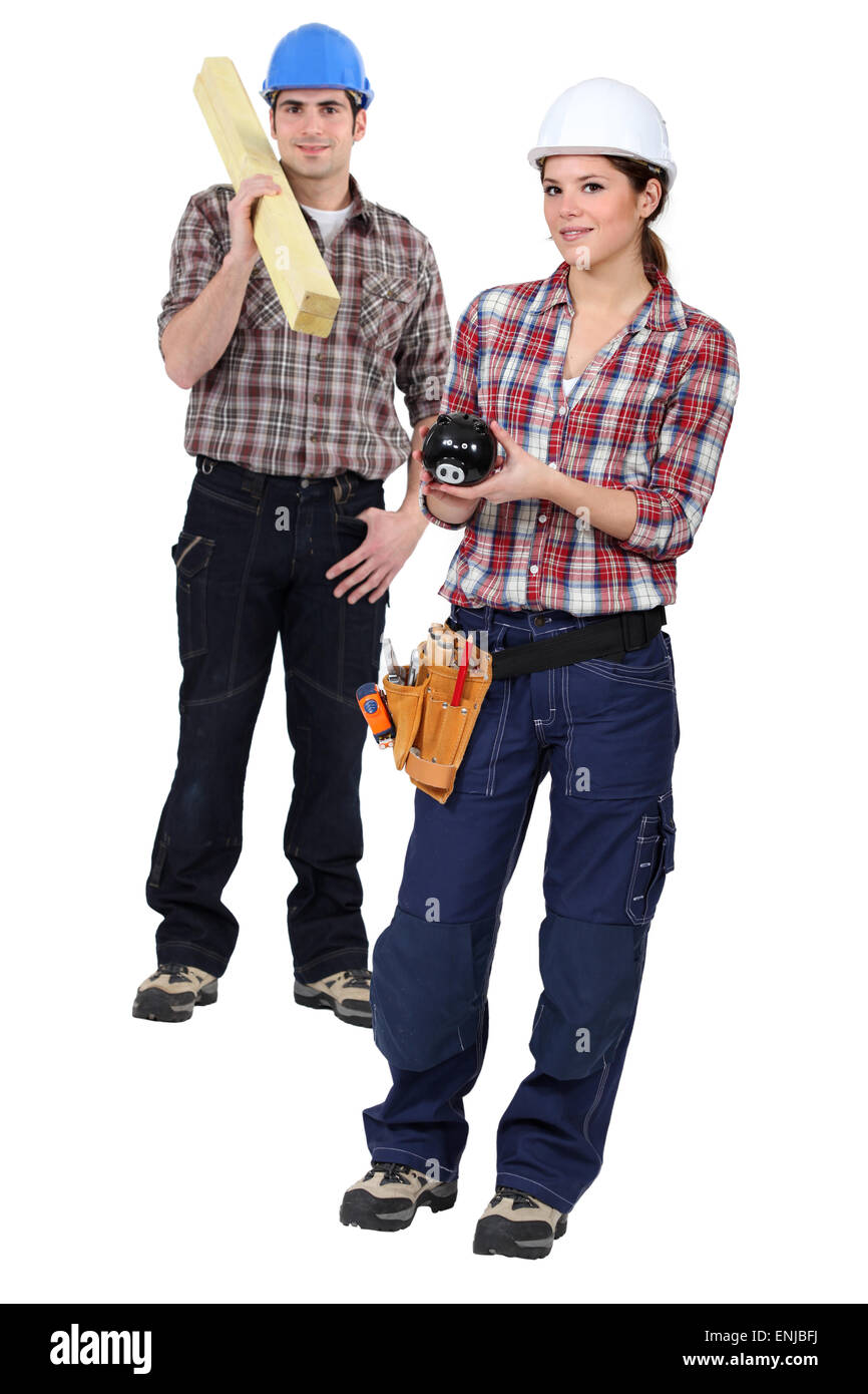 Two carpenters stood with piggy-bank Stock Photo