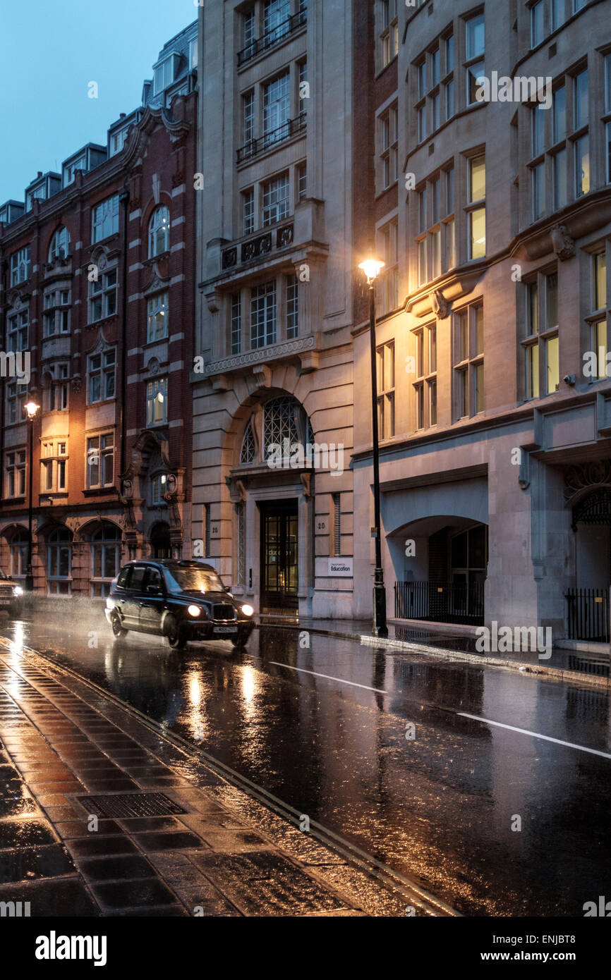 Late night taxi.Black cab in the rain,Marsham Street,London,UK Stock Photo
