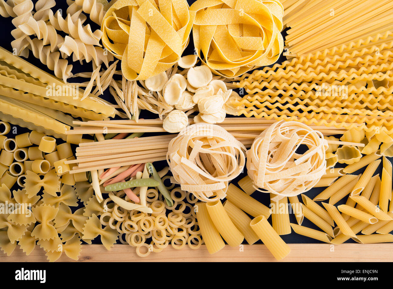 raw pasta on a wooden board, ready to be cooked Stock Photo